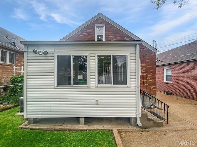 view of home's exterior with fence and brick siding