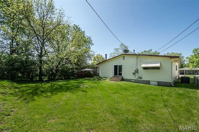 525 Angelus Dr, Florissant, MO 63031 - back of property with entry steps, a yard, and central AC