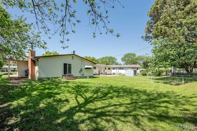 525 Angelus Dr, Florissant, MO 63031 - back of property featuring a chimney, entry steps, a shed, and an outbuilding