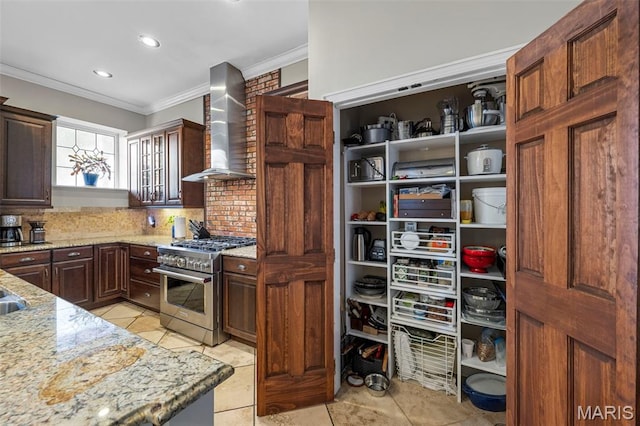 2612 S Compton Ave, Saint Louis, MO 63118 - kitchen with wall chimney exhaust hood, high end stainless steel range, ornamental molding, light stone countertops, and backsplash