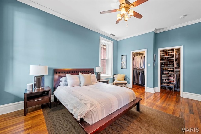 2612 S Compton Ave, Saint Louis, MO 63118 - bedroom featuring hardwood / wood-style floors, crown molding, a spacious closet, and a ceiling fan
