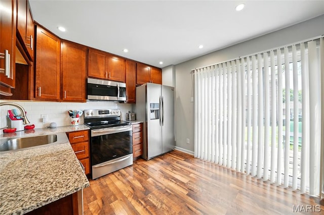 10566 Carroll Wood Way, Saint Louis, MO 63128 - kitchen with appliances with stainless steel finishes, a sink, light wood-style floors, backsplash, and recessed lighting