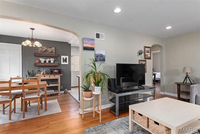 7337 Bruno Ave, Richmond Heights, MO 63117 - living area featuring arched walkways, baseboards, light wood-style floors, recessed lighting, and a chandelier