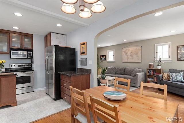 7337 Bruno Ave, Richmond Heights, MO 63117 - dining area featuring arched walkways, healthy amount of natural light, a chandelier, recessed lighting, and baseboards