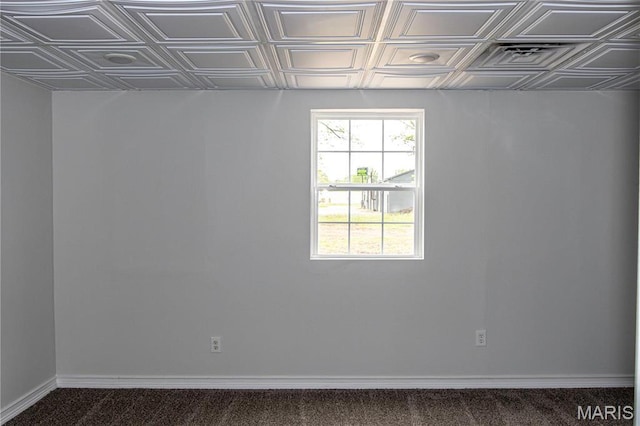 below grade area with an ornate ceiling, baseboards, and carpet