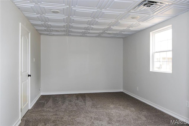 spare room featuring carpet floors, an ornate ceiling, and baseboards