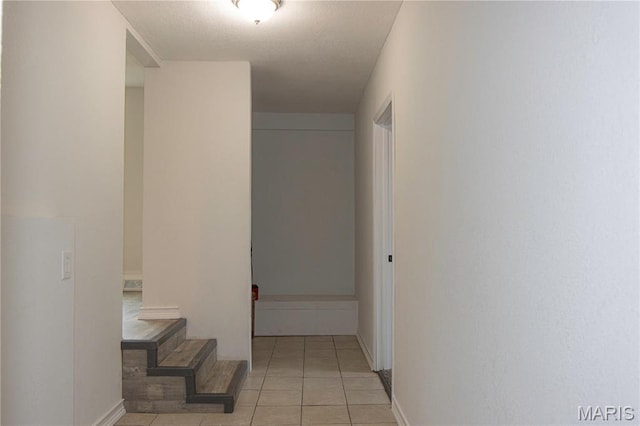 hallway with light tile patterned floors and baseboards