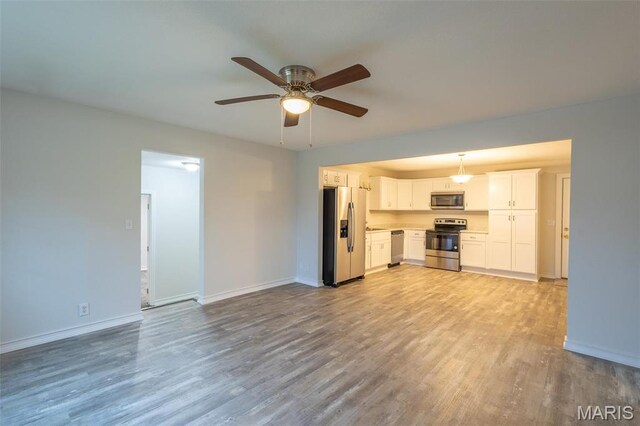 1042 Ash St, Poplar Bluff, MO 63901 - unfurnished living room with a ceiling fan, light wood-style flooring, and baseboards