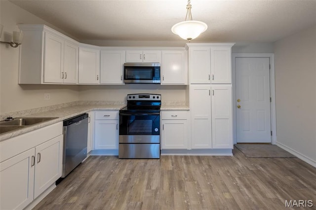 1042 Ash St, Poplar Bluff, MO 63901 - kitchen featuring stainless steel appliances, white cabinetry, light wood finished floors, and light countertops