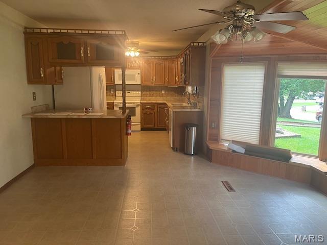 3106 Mimosa St, Cape Girardeau, MO 63701 - kitchen with white appliances, a ceiling fan, light countertops, a peninsula, and a sink