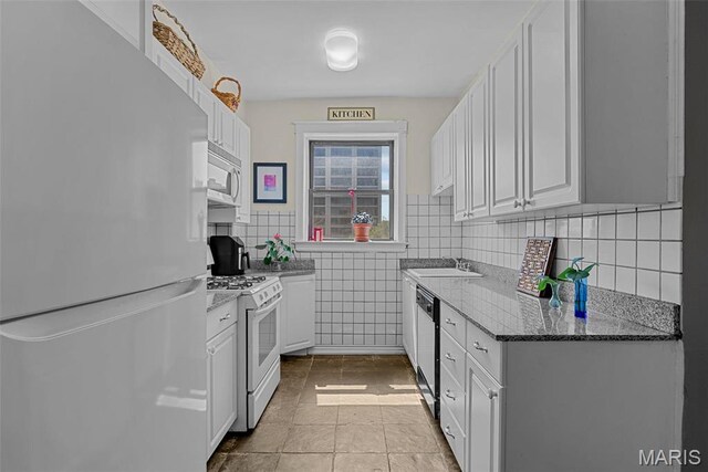4501 Maryland Ave Unit 603, Saint Louis, MO 63108 - kitchen featuring white appliances, white cabinets, dark stone countertops, a sink, and tile patterned floors