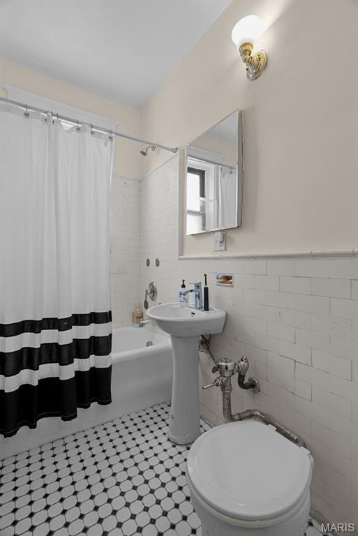4501 Maryland Ave Unit 603, Saint Louis, MO 63108 - bathroom featuring tile walls, shower / tub combo, a wainscoted wall, and toilet