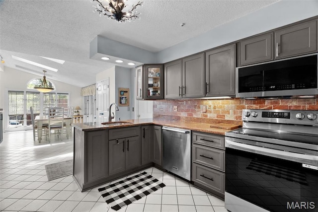 19 Sackston Woods Ln, Saint Louis, MO 63141 - kitchen featuring stainless steel appliances, gray cabinets, a peninsula, a textured ceiling, and a sink