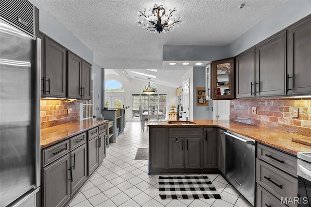19 Sackston Woods Ln, Saint Louis, MO 63141 - kitchen with stainless steel appliances, a sink, a textured ceiling, a peninsula, and light tile patterned floors