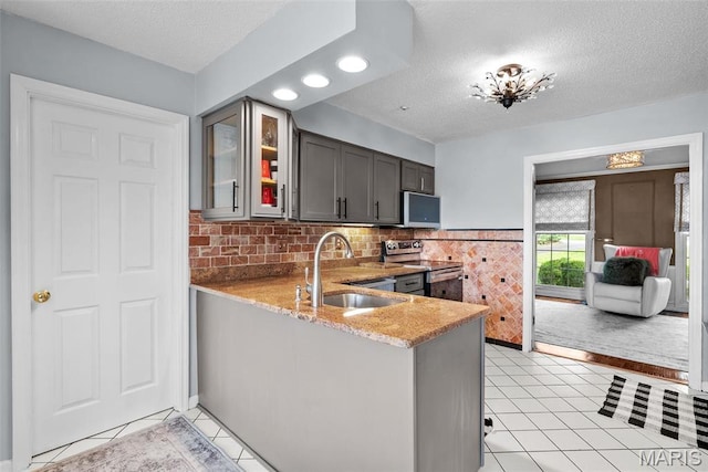 19 Sackston Woods Ln, Saint Louis, MO 63141 - kitchen featuring stainless steel appliances, a sink, a textured ceiling, light stone counters, and glass insert cabinets