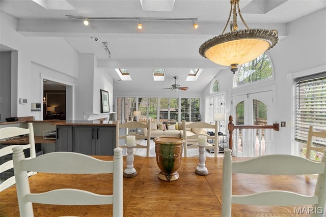 19 Sackston Woods Ln, Saint Louis, MO 63141 - dining room with a skylight, lofted ceiling, rail lighting, and a ceiling fan