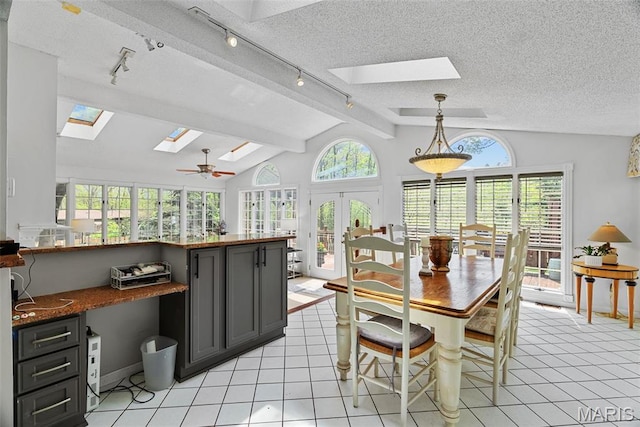 19 Sackston Woods Ln, Saint Louis, MO 63141 - dining area with a skylight, rail lighting, a textured ceiling, french doors, and light tile patterned floors