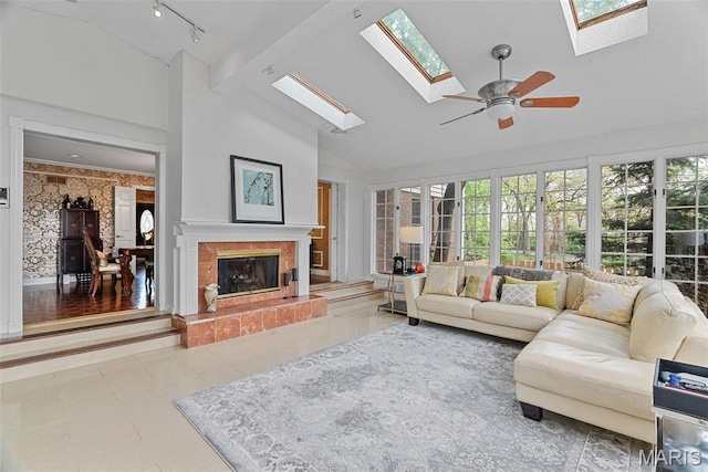 19 Sackston Woods Ln, Saint Louis, MO 63141 - living room with a skylight, high vaulted ceiling, a tiled fireplace, a ceiling fan, and rail lighting
