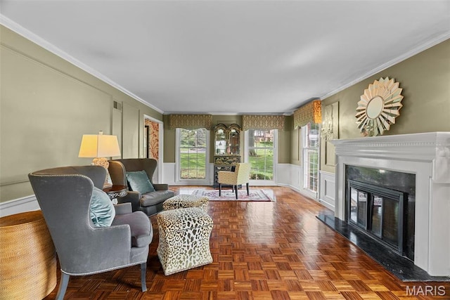 19 Sackston Woods Ln, Saint Louis, MO 63141 - living area featuring ornamental molding, a decorative wall, a glass covered fireplace, baseboards, and wainscoting