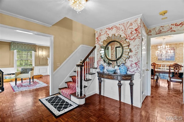 19 Sackston Woods Ln, Saint Louis, MO 63141 - staircase featuring a chandelier, wallpapered walls, crown molding, a decorative wall, and wainscoting