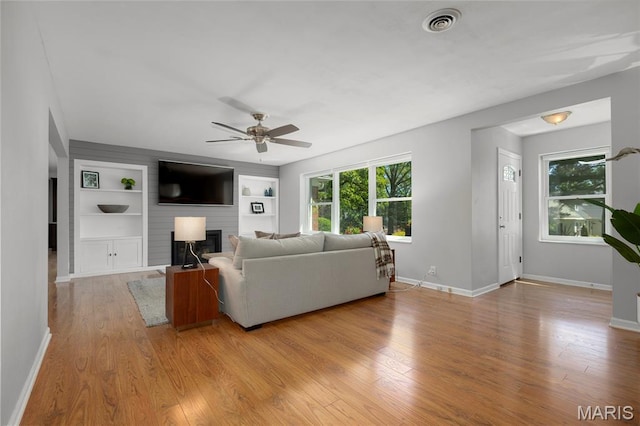 1345 Cheshire Ln, Webster Groves, MO 63119 - living room featuring ceiling fan, light wood-type flooring, and healthy amount of natural light