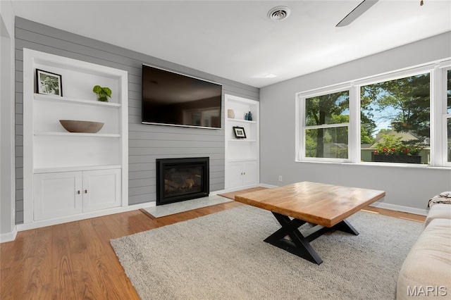 1345 Cheshire Ln, Webster Groves, MO 63119 - living area with built in features, wood finished floors, a fireplace, and baseboards