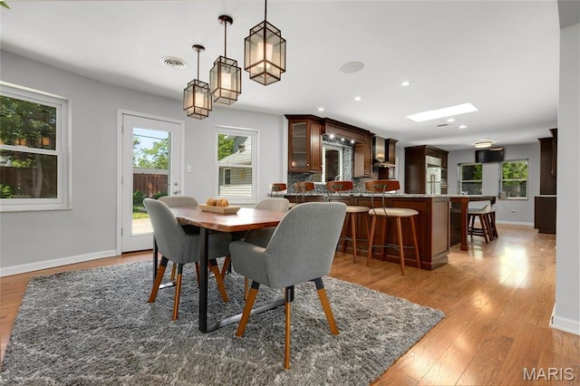 1345 Cheshire Ln, Webster Groves, MO 63119 - dining room featuring light wood-style flooring, baseboards, recessed lighting, and a skylight