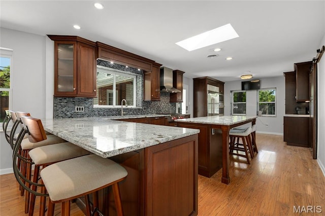 1345 Cheshire Ln, Webster Groves, MO 63119 - kitchen with a skylight, a sink, backsplash, light wood-style floors, and baseboards