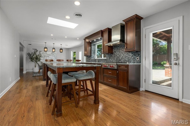 1345 Cheshire Ln, Webster Groves, MO 63119 - kitchen with wall chimney exhaust hood, stainless steel gas cooktop, recessed lighting, a kitchen island, and decorative backsplash