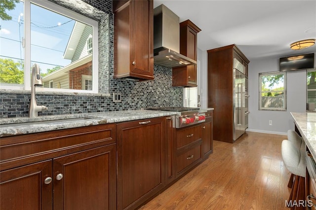1345 Cheshire Ln, Webster Groves, MO 63119 - kitchen with wall chimney range hood, stainless steel gas cooktop, a sink, light wood-style floors, and baseboards