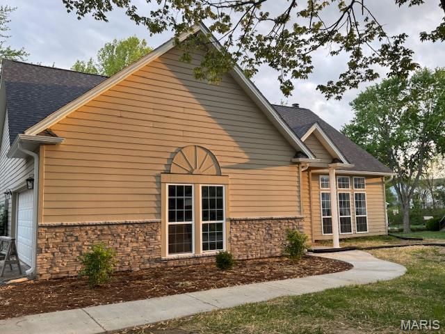 1553 Valley Forge Ln, Cape Girardeau, MO 63701 - view of side of property featuring a garage, roof with shingles, and stone siding