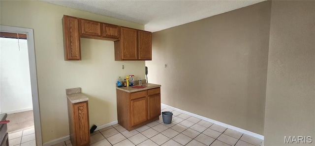 2311 State St, Chester, IL 62233 - kitchen with brown cabinets, light tile patterned floors, light countertops, a textured ceiling, and baseboards
