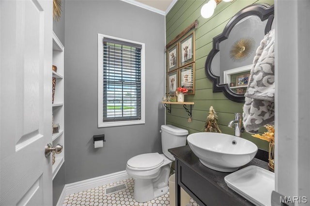 bathroom featuring ornamental molding, wooden walls, tile patterned floors, toilet, and double vanity
