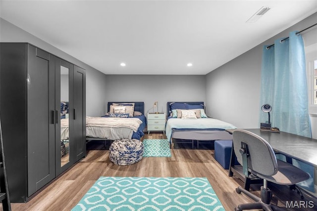 bedroom featuring light wood-type flooring, recessed lighting, and a desk