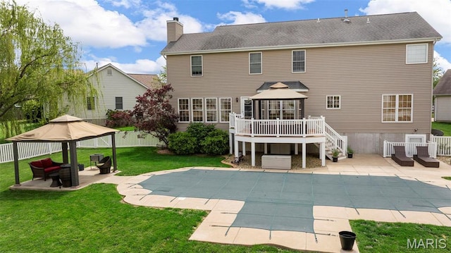rear view of house with a gazebo, a patio, a chimney, and a deck