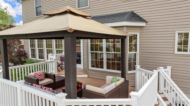 wooden terrace with an outdoor living space and a gazebo