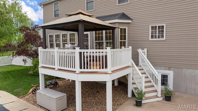 rear view of property featuring a gazebo, a wooden deck, and stairs