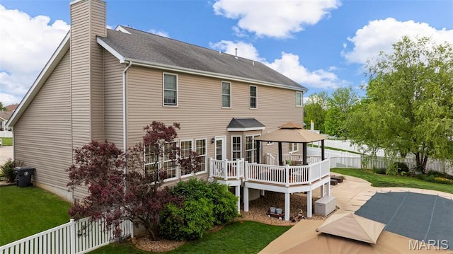 back of house with a gazebo, a chimney, a deck, and a patio area