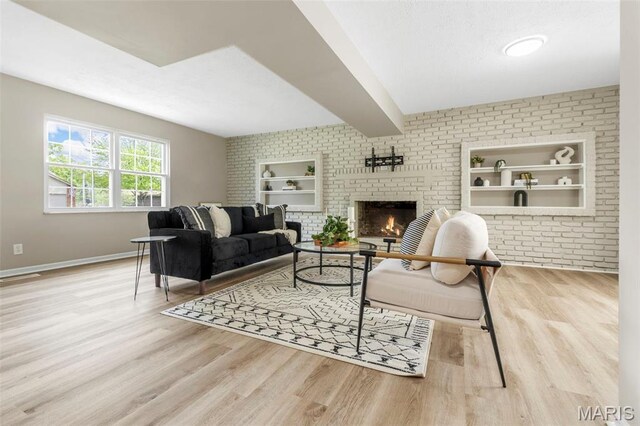948 Barbara Ann Ln, Ellisville, MO 63021 - living area with wood finished floors, built in shelves, brick wall, a brick fireplace, and beam ceiling