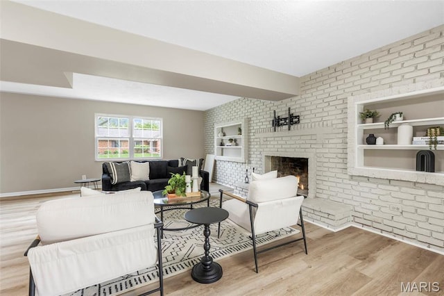 948 Barbara Ann Ln, Ellisville, MO 63021 - living room featuring wood finished floors, brick wall, a brick fireplace, and built in features