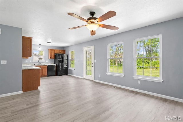 705 Fulton St, Gillespie, IL 62033 - unfurnished living room with baseboards, light wood finished floors, and a ceiling fan