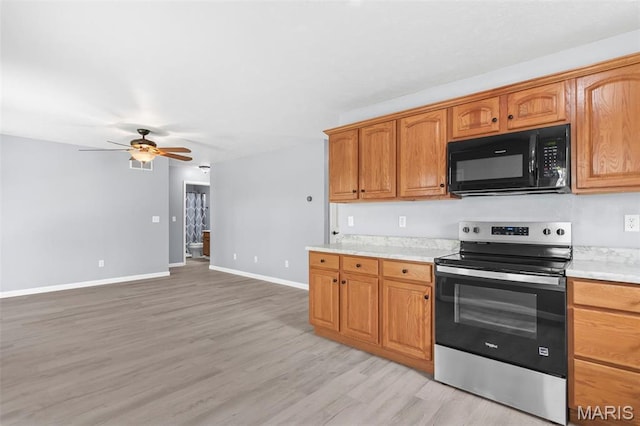 705 Fulton St, Gillespie, IL 62033 - kitchen featuring electric range, black microwave, light countertops, light wood finished floors, and ceiling fan