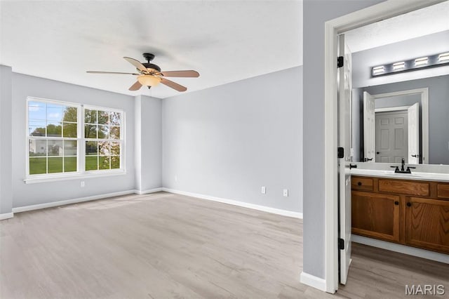 705 Fulton St, Gillespie, IL 62033 - unfurnished living room with ceiling fan, light wood-style flooring, a sink, and baseboards