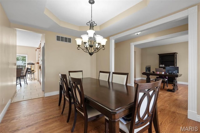 dining room with a chandelier, wood finished floors, baseboards, and a desk