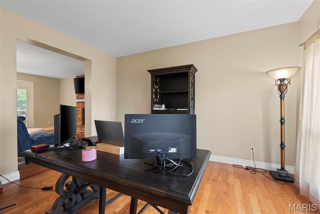 office space featuring light wood-type flooring and baseboards