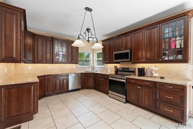kitchen with appliances with stainless steel finishes, decorative backsplash, light tile patterned floors, and dark brown cabinetry
