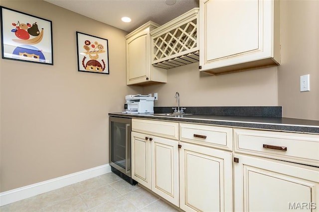 100 Waterfall Ct, Glen Carbon, IL 62034 - kitchen featuring cream cabinetry, a sink, wine cooler, dark countertops, and recessed lighting