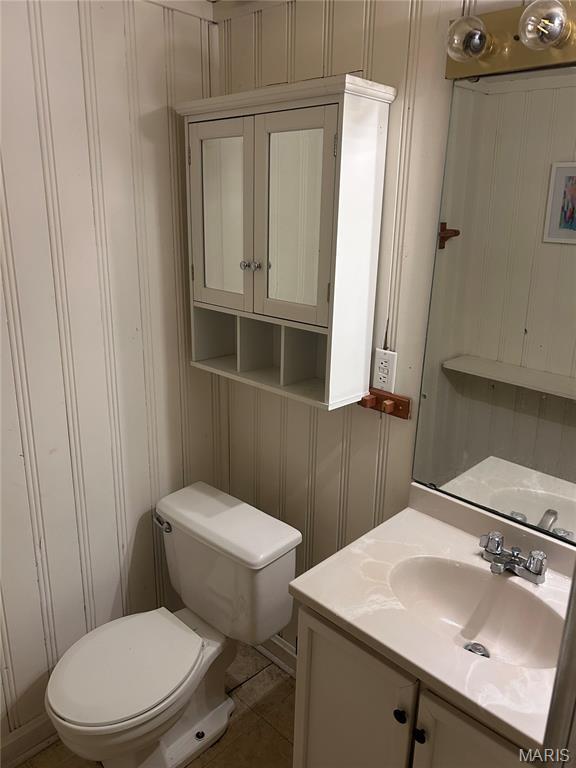 943 Warder Ave, Saint Louis, MO 63130 - half bathroom featuring toilet, vanity, and a decorative wall