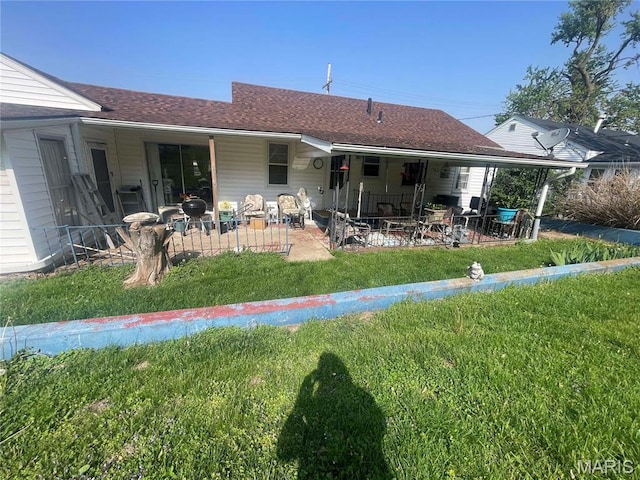 back of house with a lawn, a patio, and a shingled roof