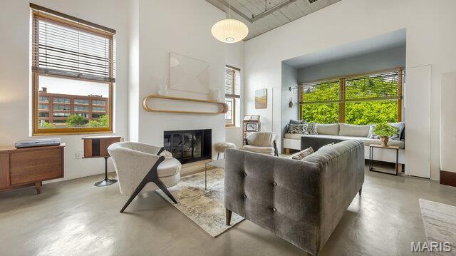 4100 Laclede Ave Unit 314, Saint Louis, MO 63108 - living area featuring concrete floors, a glass covered fireplace, and a high ceiling